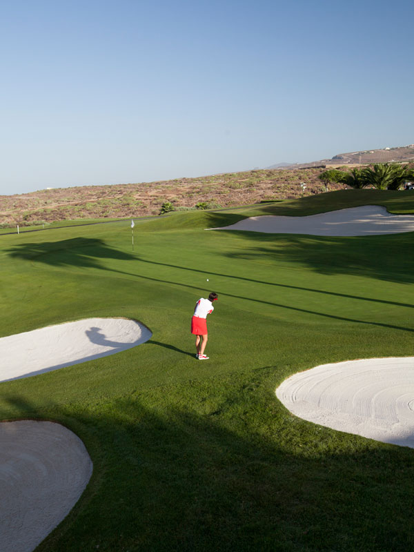 Giocatore di golf sul campo Abama a Tenerife, vicino alla buca e a un bunker.