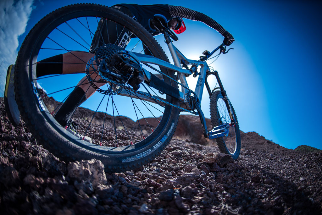 Ciclista in mountain bike su terreni rocciosi a Tenerife sotto cieli azzurri.