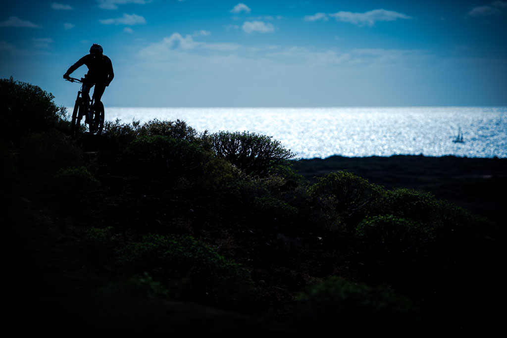 Ciclista su un sentiero costiero con vista sul mare a Tenerife.