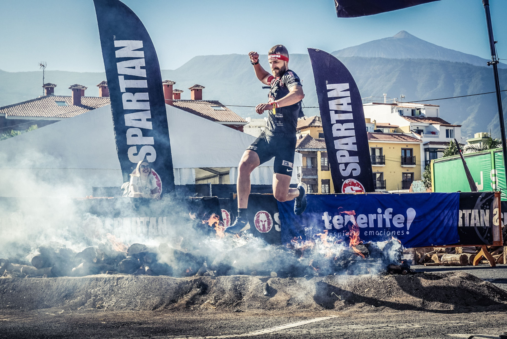 Corridore che salta sopra il fuoco in una gara spartana a Tenerife.