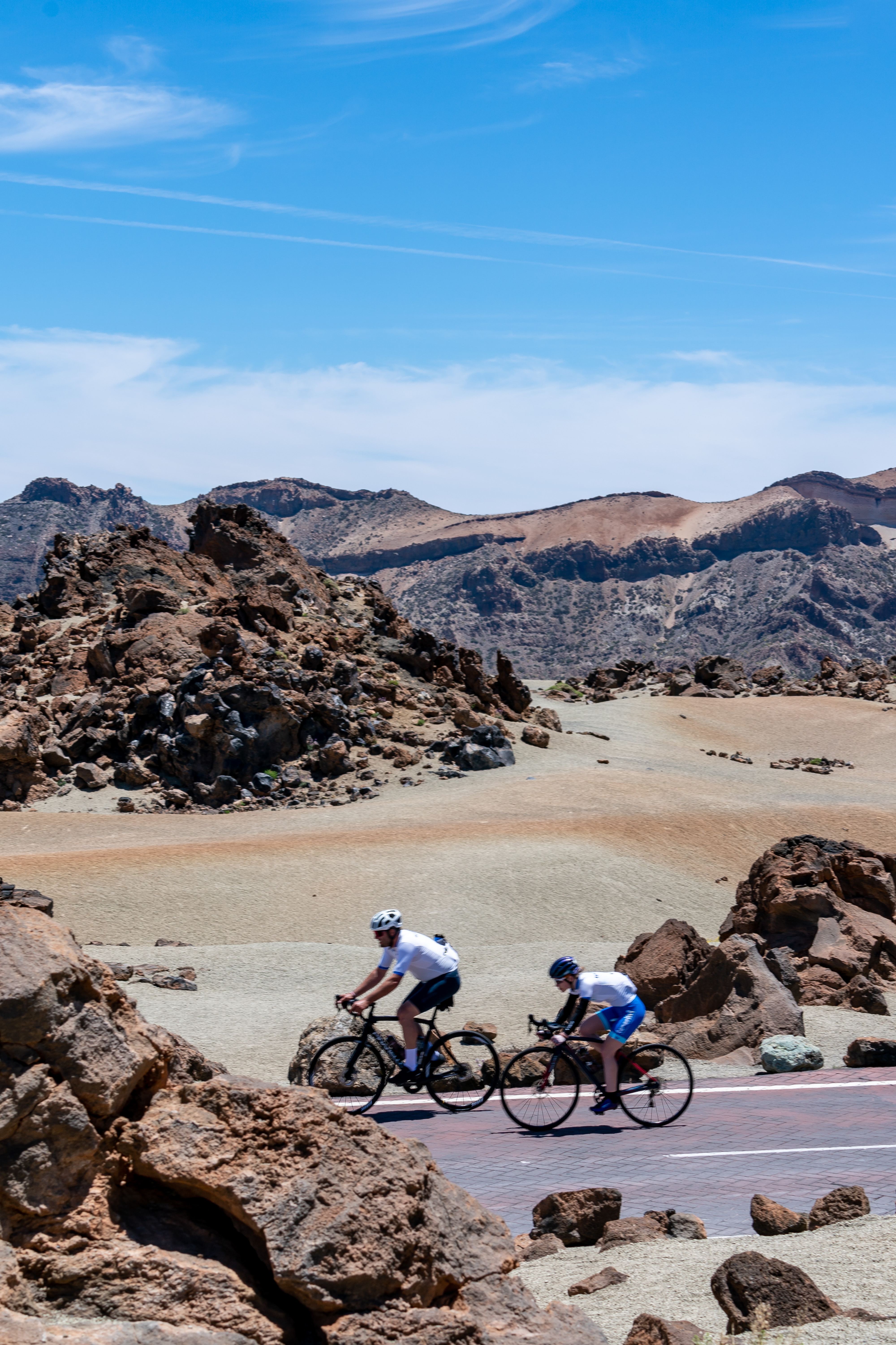 Ciclisti che attraversano il paesaggio vulcanico del Parco Nazionale del Teide, Tenerife.