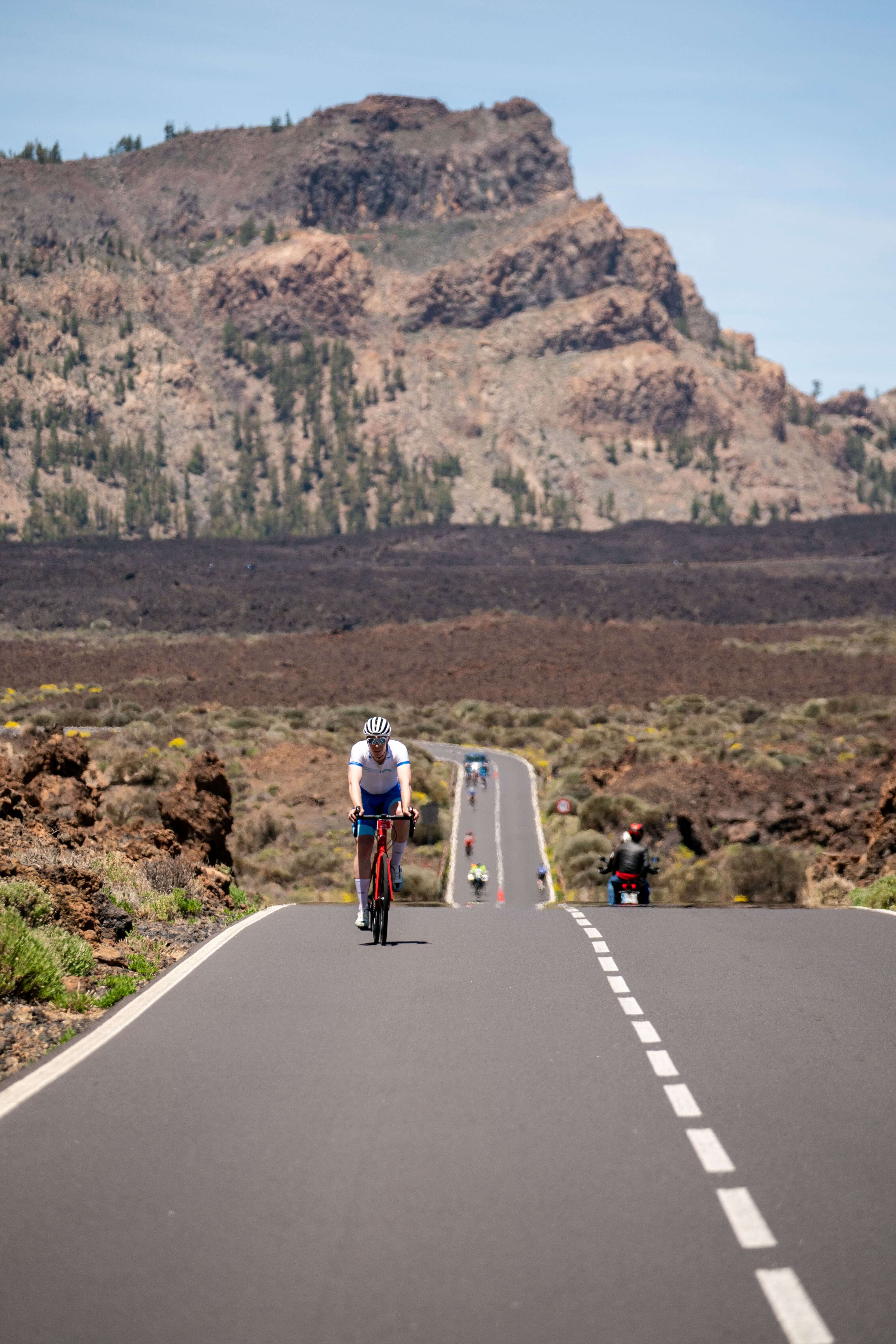 Ciclista sulla strada verso il Monte Teide a Tenerife, circondato da paesaggi vulcanici.
