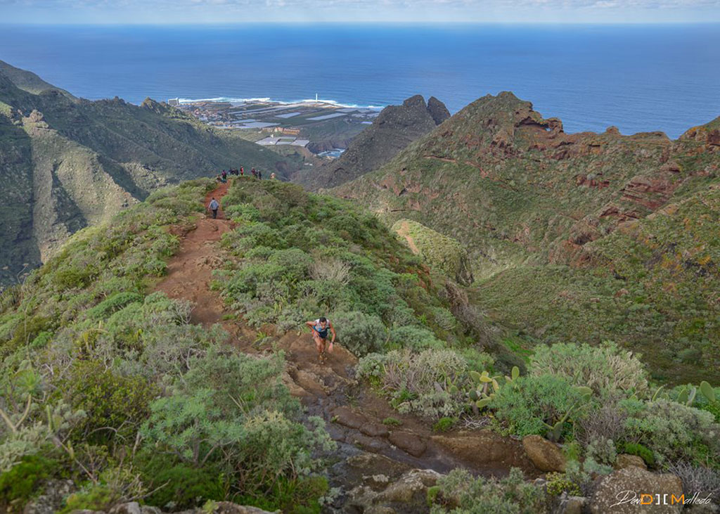 Sentiero di montagna ad Anaga, Tenerife, con vista sull'oceano e escursionisti.