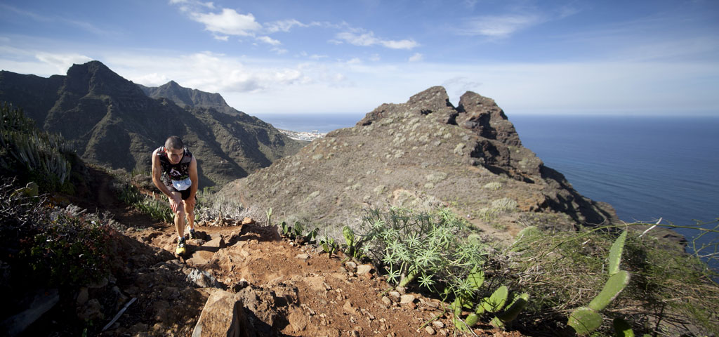 Persona che scala la collina con vista sul mare e sulle montagne a Tenerife.