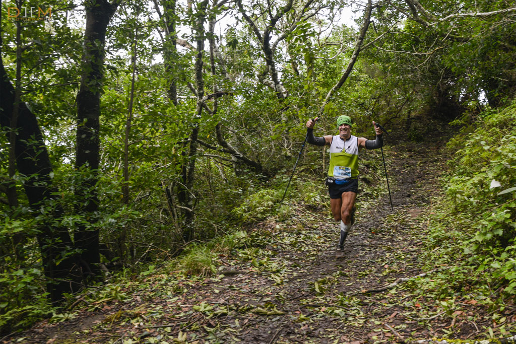 Corridore con i bastoncini sul sentiero boscoso di Tenerife.