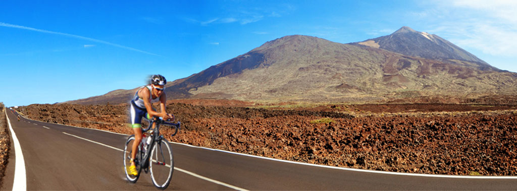 Ciclista su strada accanto al Monte Teide a Tenerife.