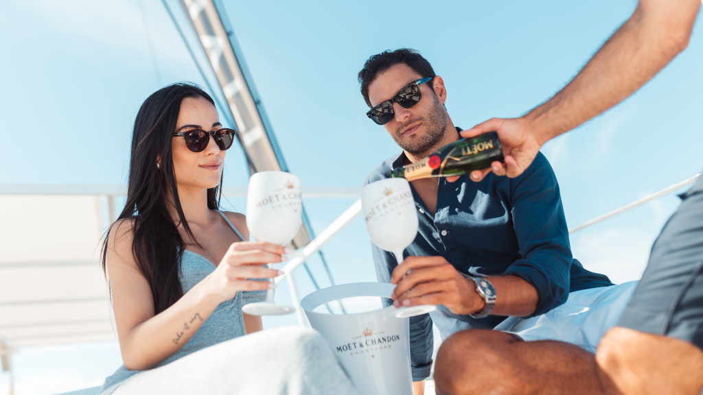Persone che brindano con lo champagne Moët & Chandon su uno yacht a Tenerife.