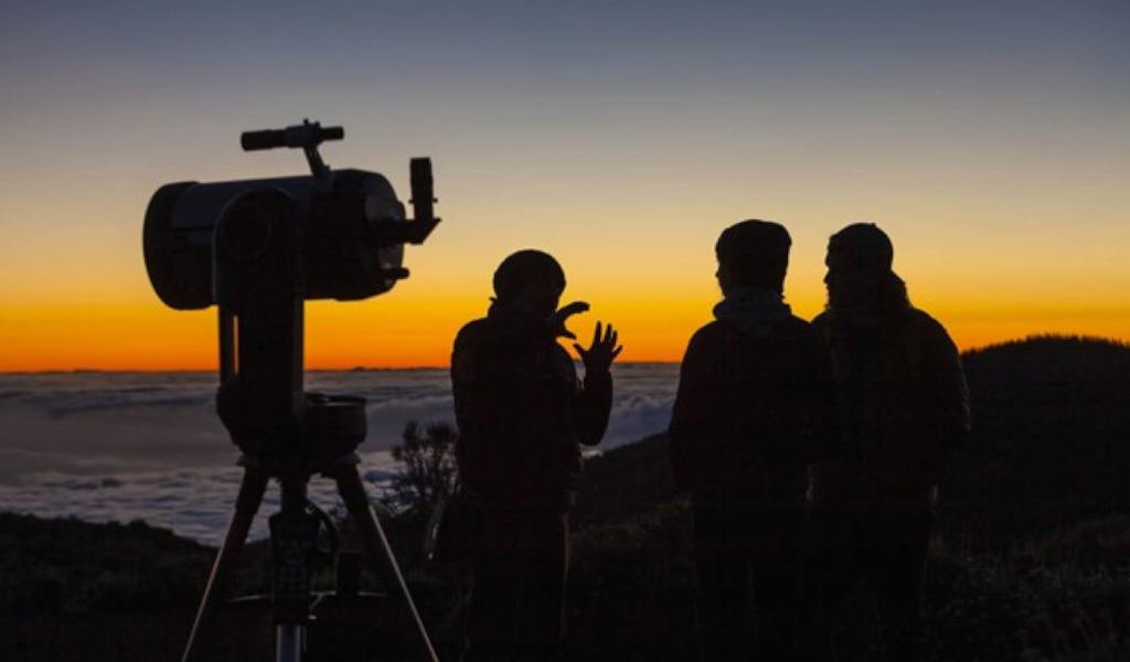 Persone che guardano l'alba con un telescopio a Tenerife.