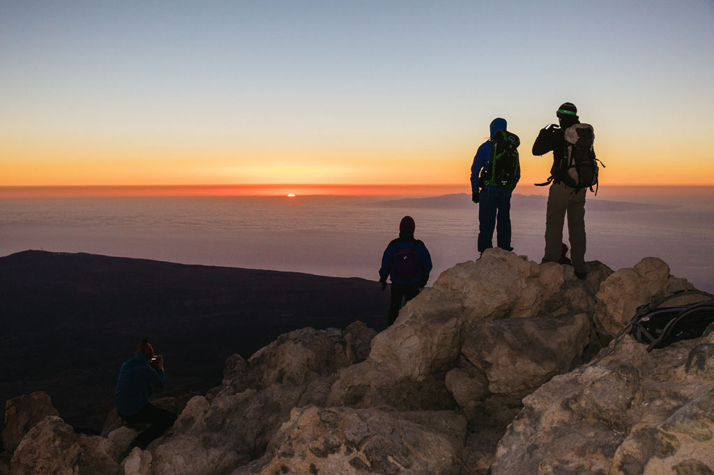 Alpinisti che osservano l'alba dalla vetta del Monte Teide a Tenerife.