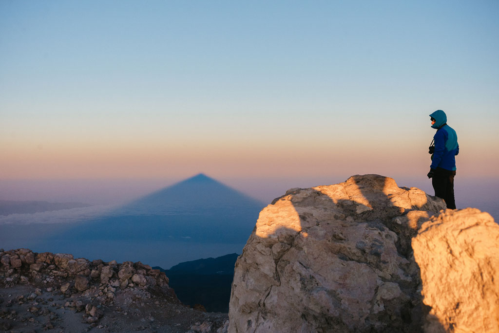 Persona che osserva l'ombra del Pico del Teide all'alba a Tenerife.