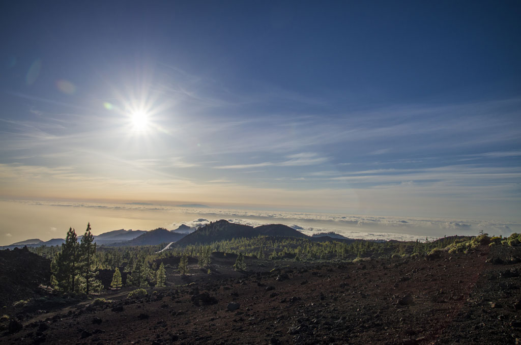Paesaggio montuoso del Parco Nazionale del Teide con cieli sereni e sole splendente.