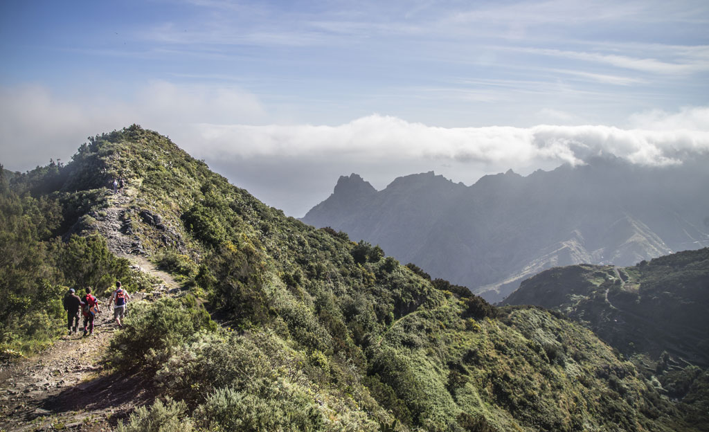 Sentiero montuoso a Tenerife con escursionisti e nuvole all'orizzonte.