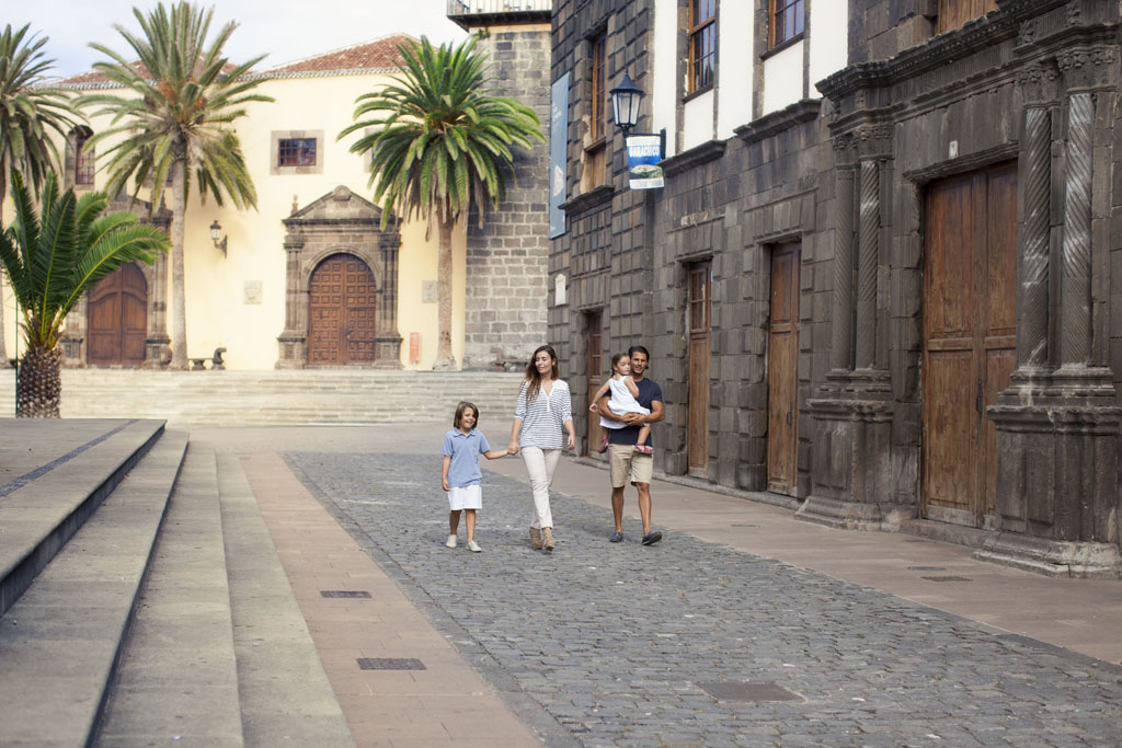 Famiglia che cammina lungo la strada con edifici storici a La Laguna, Tenerife.