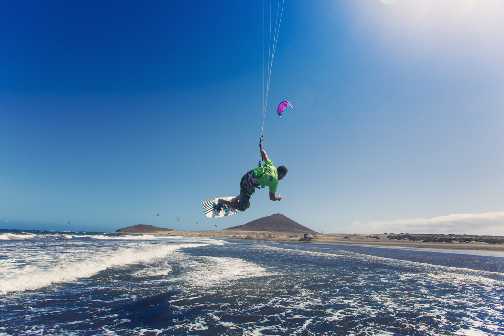 Persona che fa kitesurf sulla spiaggia di El Médano, Tenerife, con cieli sereni.