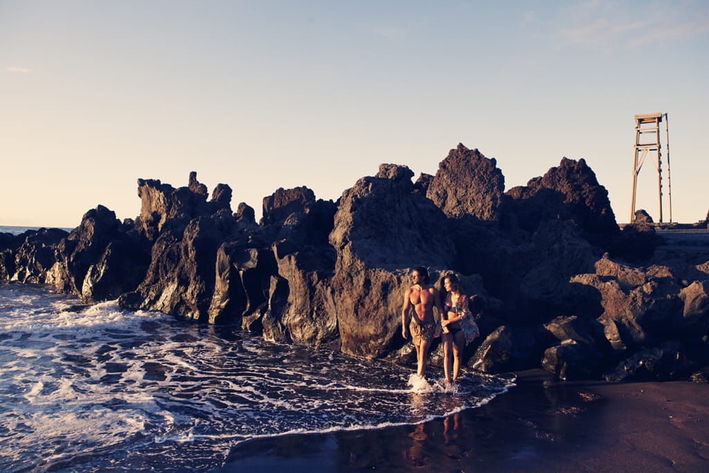 Persone che camminano lungo la spiaggia accanto alle rocce a Bajamar, Tenerife.