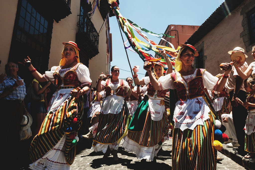 Persone in abiti tradizionali ballano in una strada di Tenerife.
