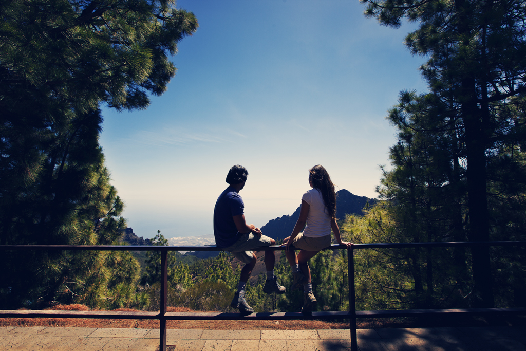 Due persone sedute su un punto panoramico che domina il mare a Tenerife.