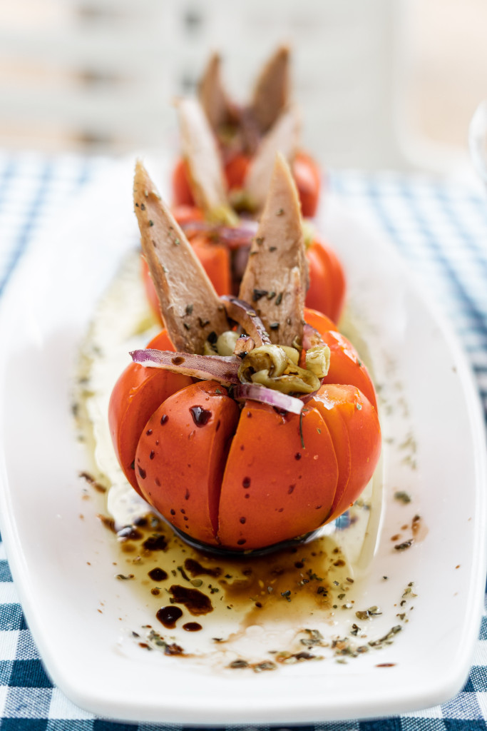 Pomodori ripieni di tonno e cipolla su un piatto bianco su un tavolo a Tenerife.