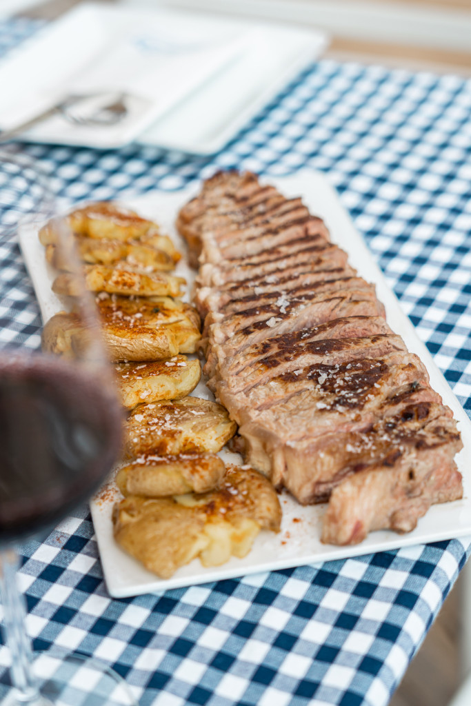 Carne alla griglia con patate su un piatto su una tovaglia a scacchi a Tenerife.