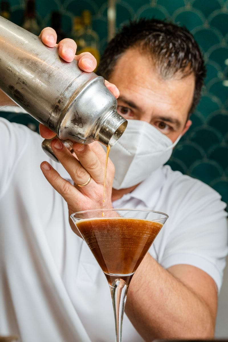 Mixologista che serve bevande in bicchiere di Martini a Tenerife.