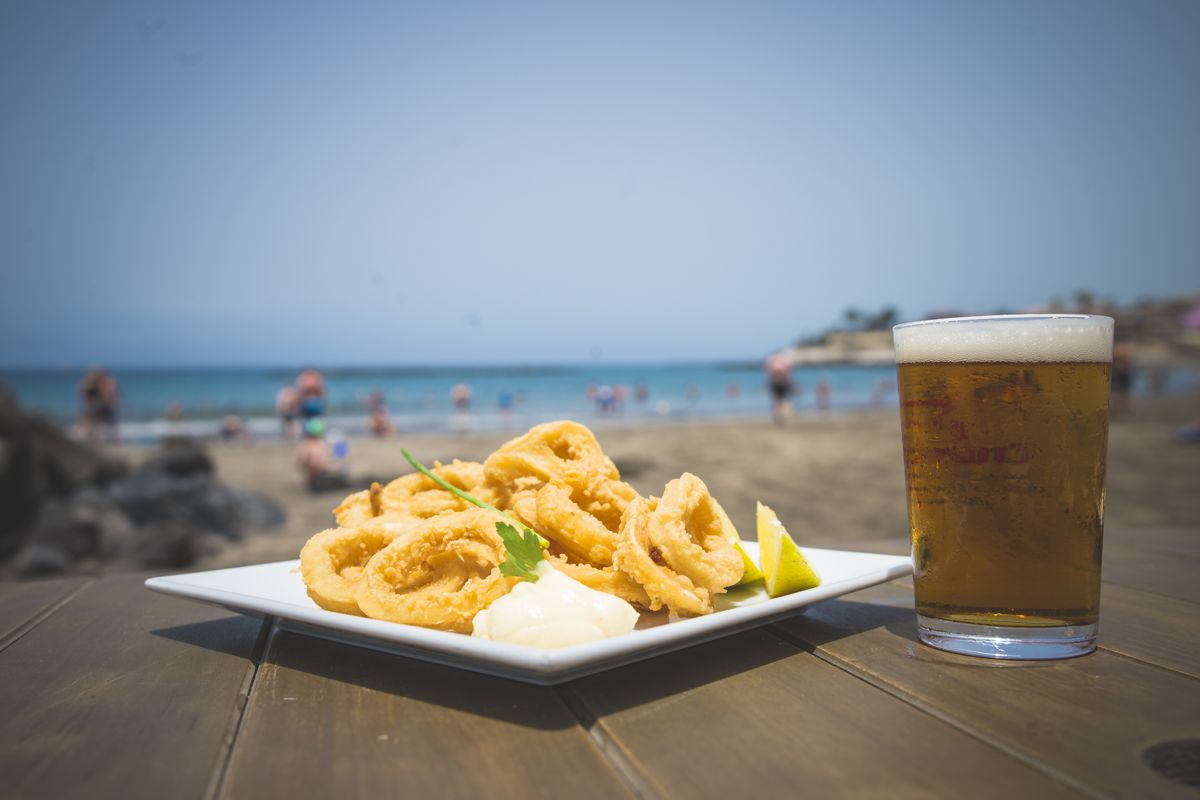 Calamari fritti con limone e birra sulla spiaggia di Adeje, Tenerife.