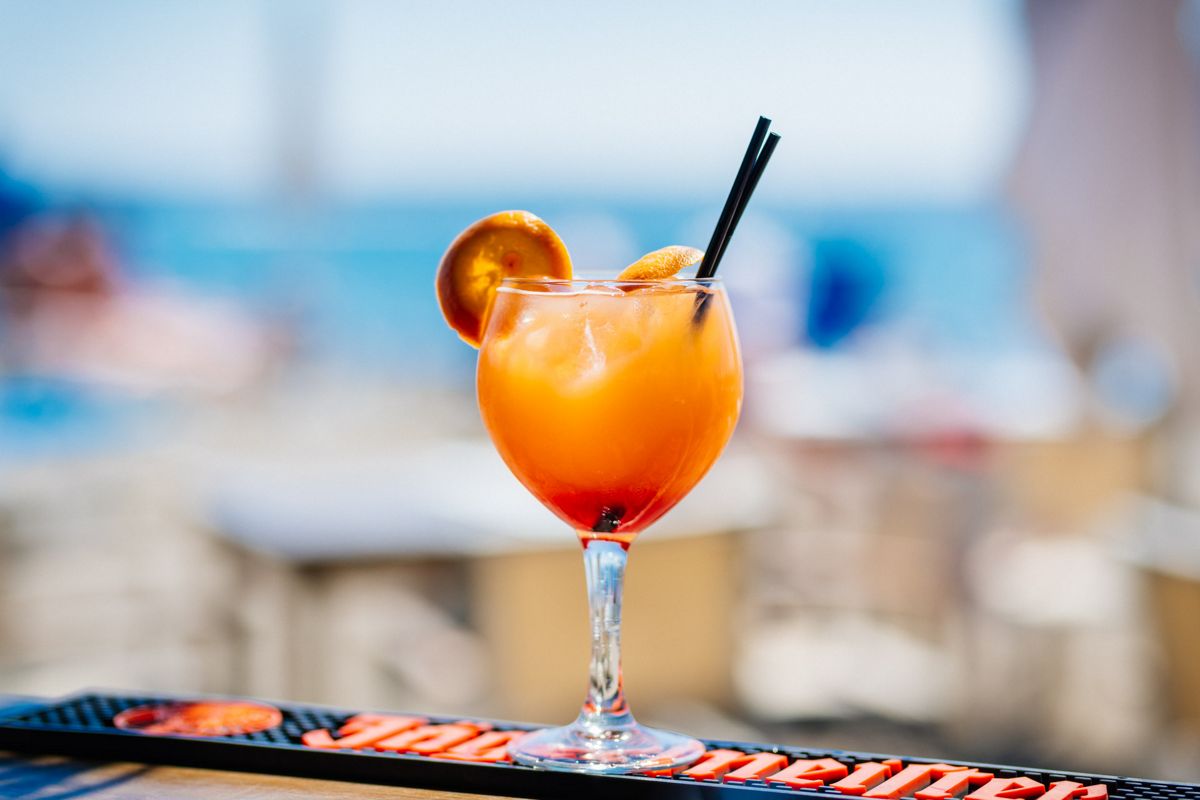 Cocktail con fetta d'arancia e due cannucce nere in un bar a Tenerife.