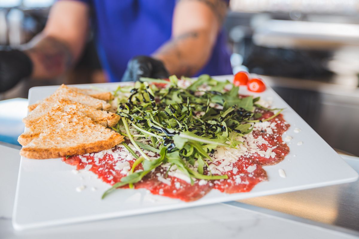 Carpaccio di manzo con rucola e pane tostato in un ristorante a Tenerife.