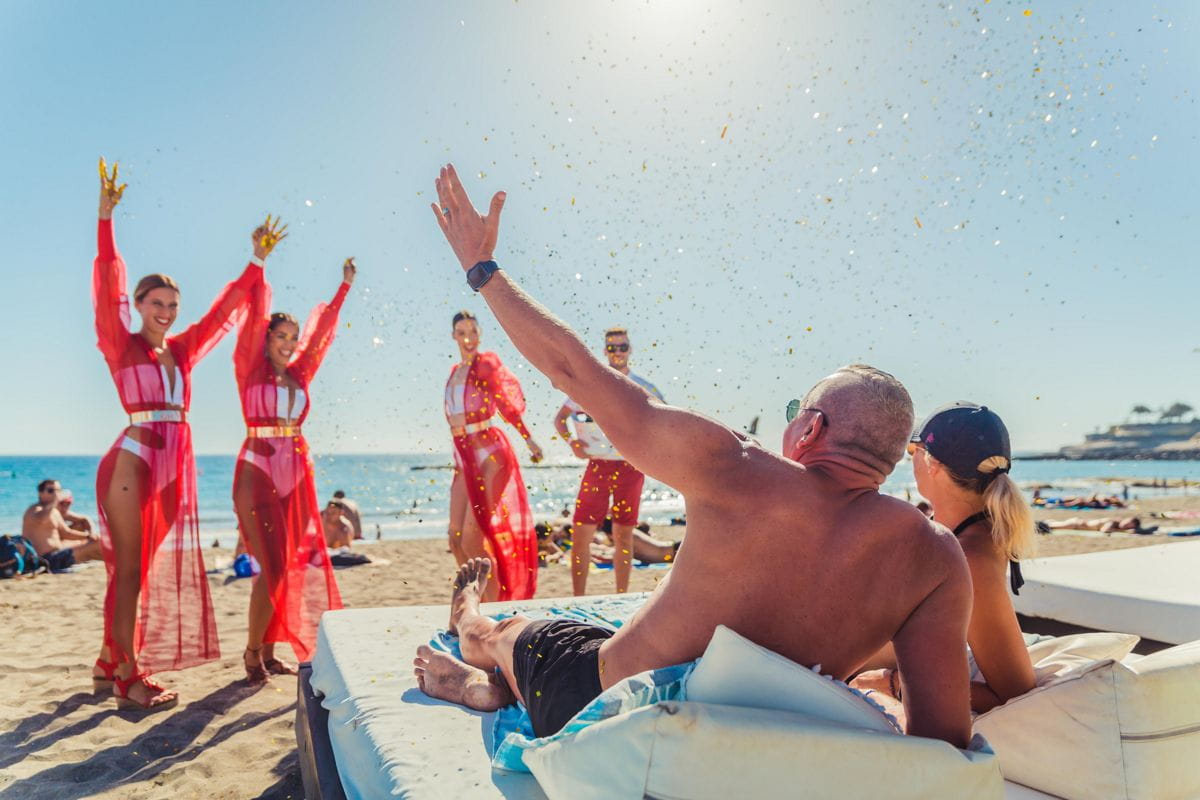 Persone che si godono la spiaggia con i ballerini a Puerto de la Cruz, Tenerife.