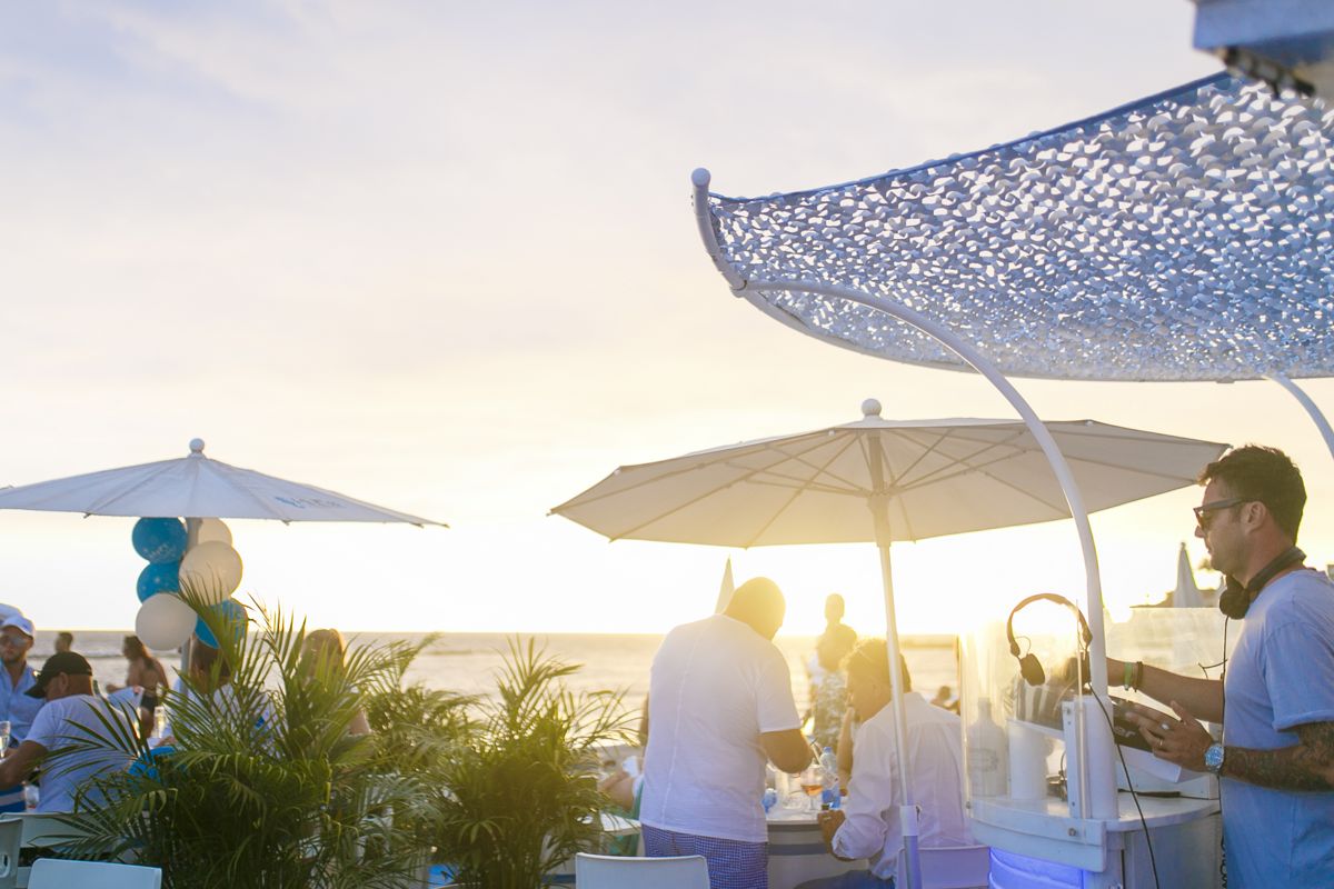 Le persone si divertono su una terrazza sul mare a Tenerife al tramonto.