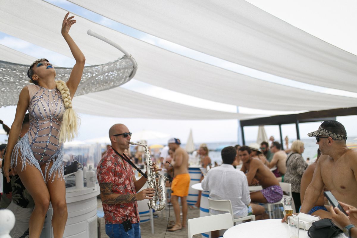 Ballerina e musicista che suona il sassofono in un evento all'aperto sulla spiaggia di Tenerife.