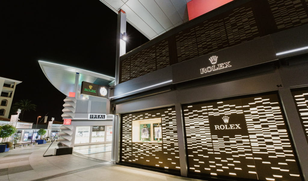 Negozio Rolex illuminato di notte in un centro commerciale a Tenerife.