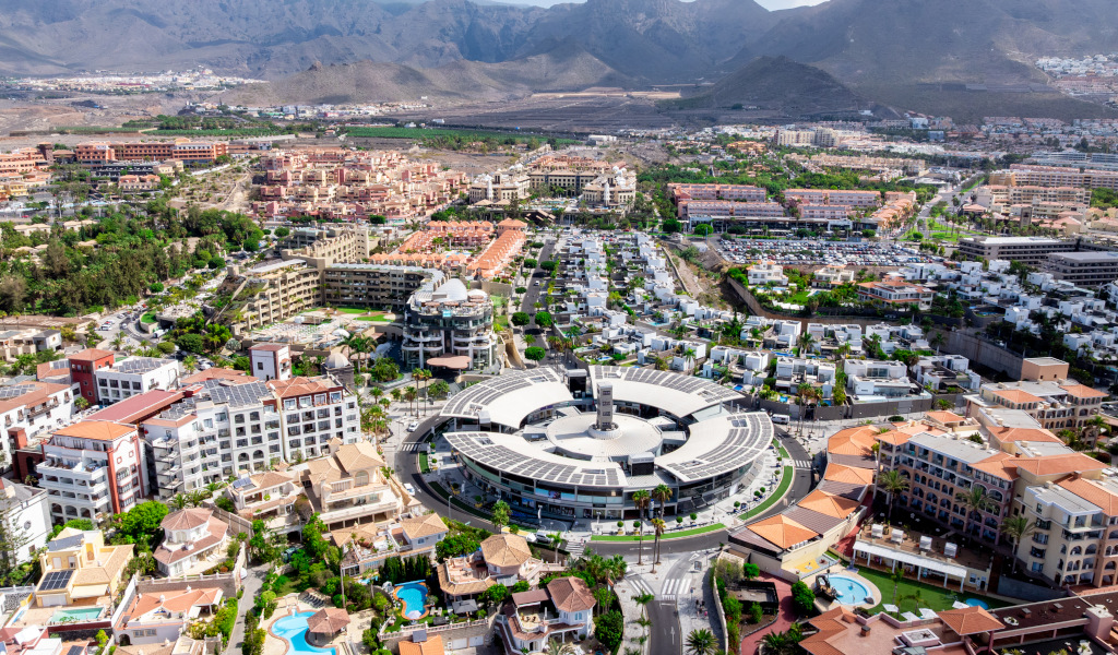 Vista aerea di Costa Adeje a Tenerife con edifici e montagne sullo sfondo.