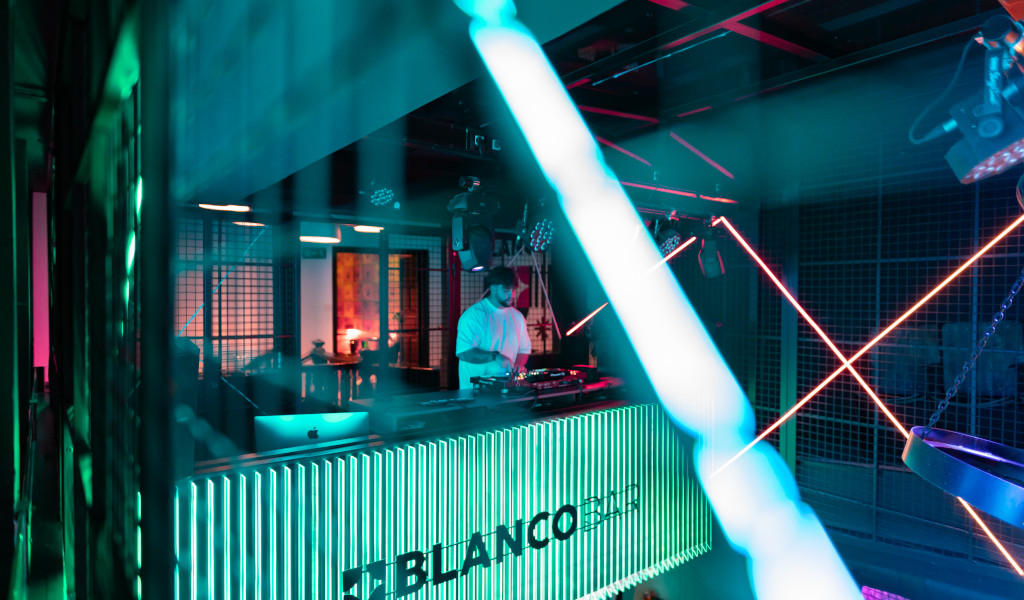 DJ che suonava musica al Blanco Bar, Tenerife, illuminato da luci al neon.