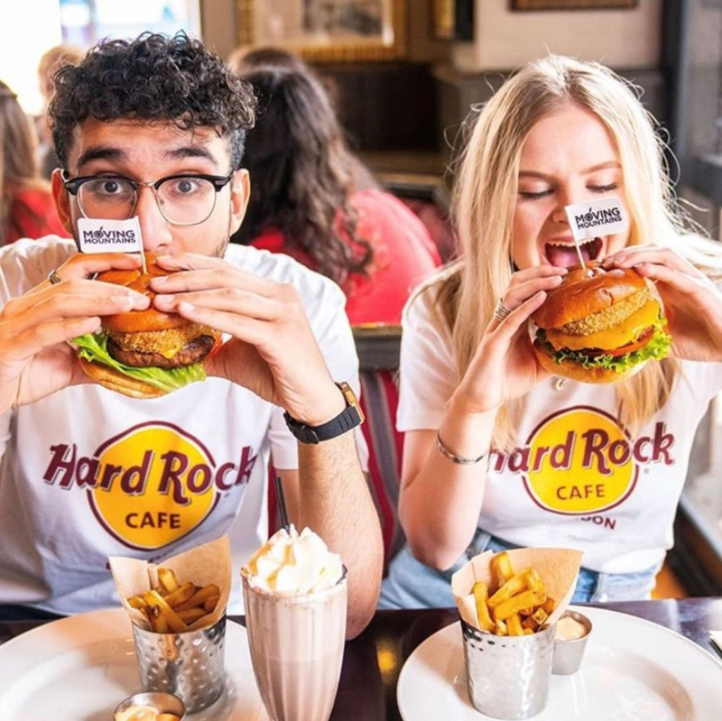Persone che si godono hamburger all'Hard Rock Cafe Tenerife.