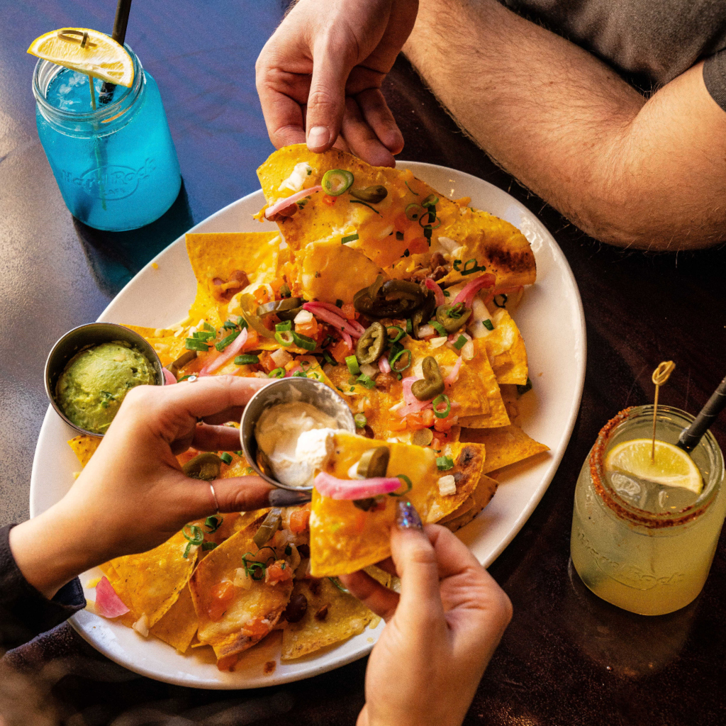 Nachos con guacamole e panna acida in un ristorante a Tenerife, accompagnati da bevande.
