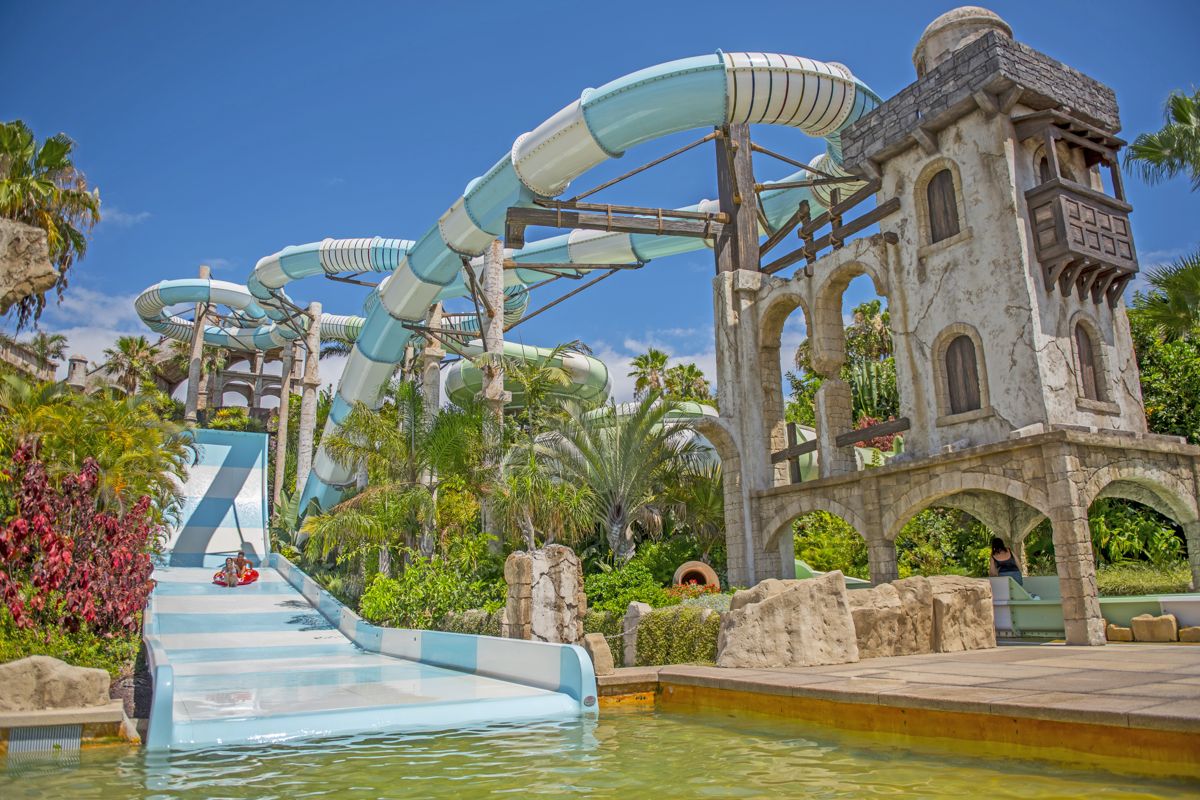 Scivolo d'acqua nel parco tematico di Tenerife con vegetazione tropicale.