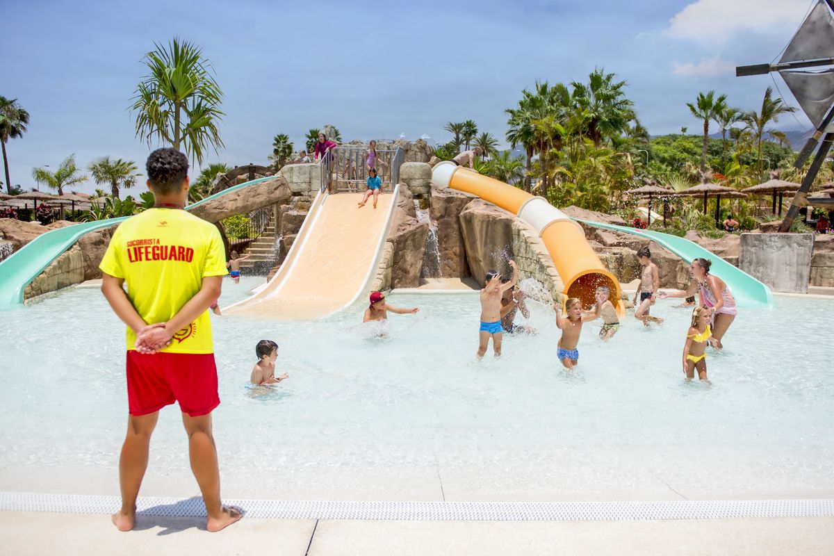 Bagnino che osserva i bambini che giocano sugli scivoli al parco acquatico di Tenerife.