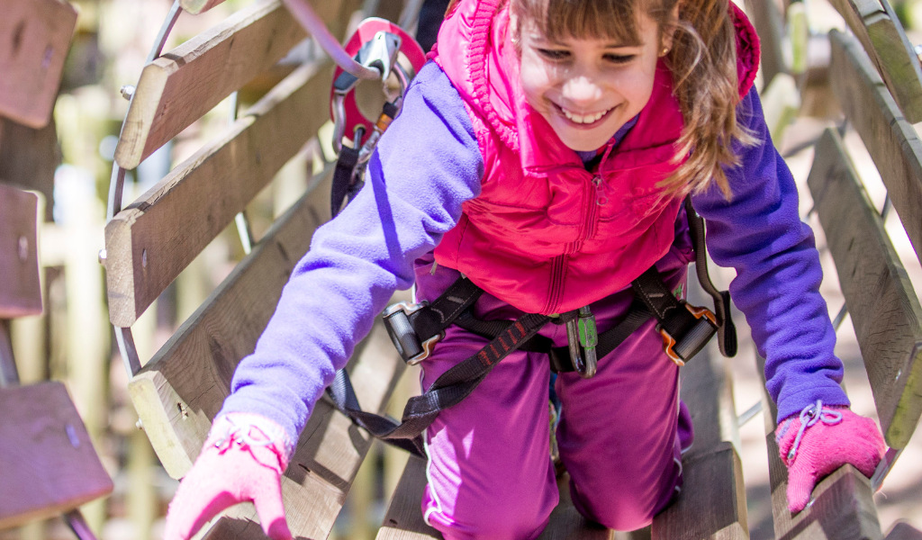 Bambina che arrampica in un parco avventure a Tenerife.