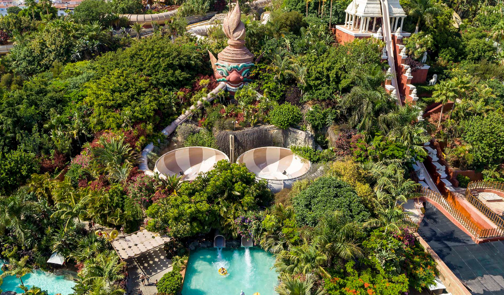Vista aerea del parco acquatico Siam Park a Tenerife con scivoli e vegetazione rigogliosa.