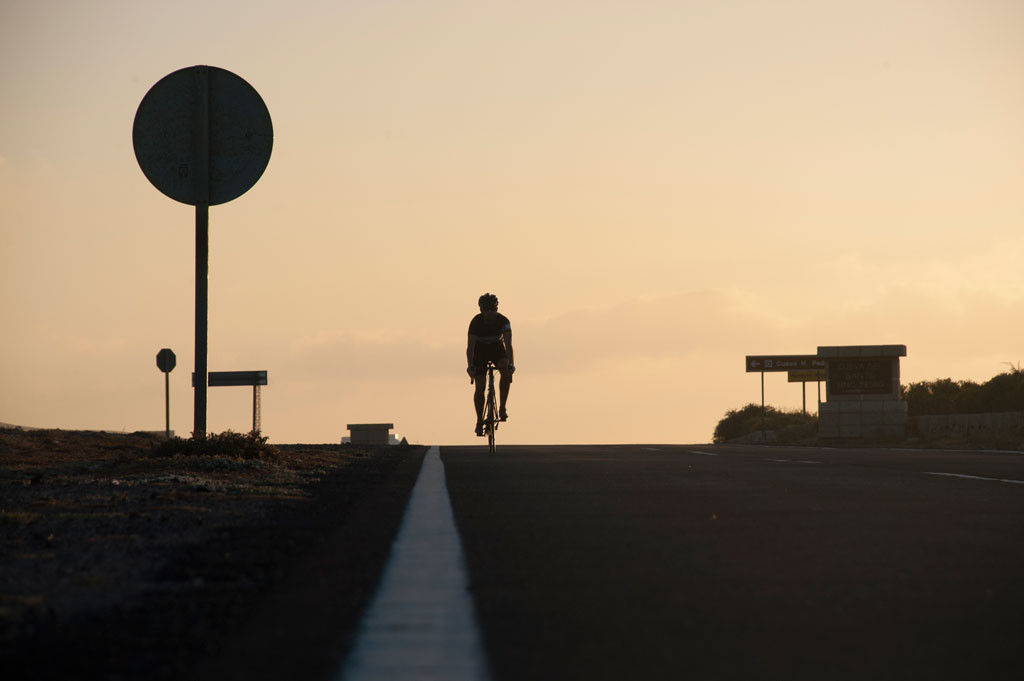 Ciclista su strada al tramonto a Tenerife.