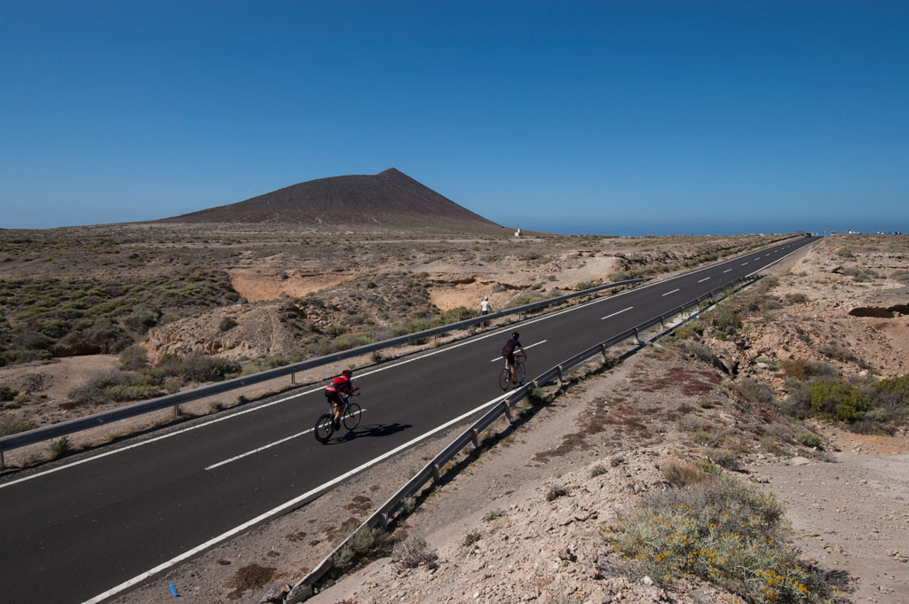 Ciclisti sulla strada verso le montagne di Tenerife sotto cieli sereni.