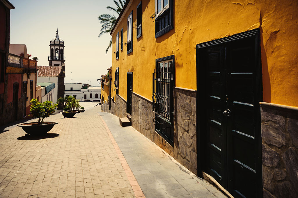 Strada acciottolata e edifici colorati a La Orotava, Tenerife. La torre della chiesa sullo sfondo.