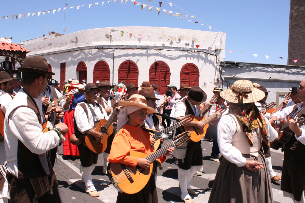 Gruppo di persone in costumi tradizionali che suonano la chitarra a una festa a Tenerife.