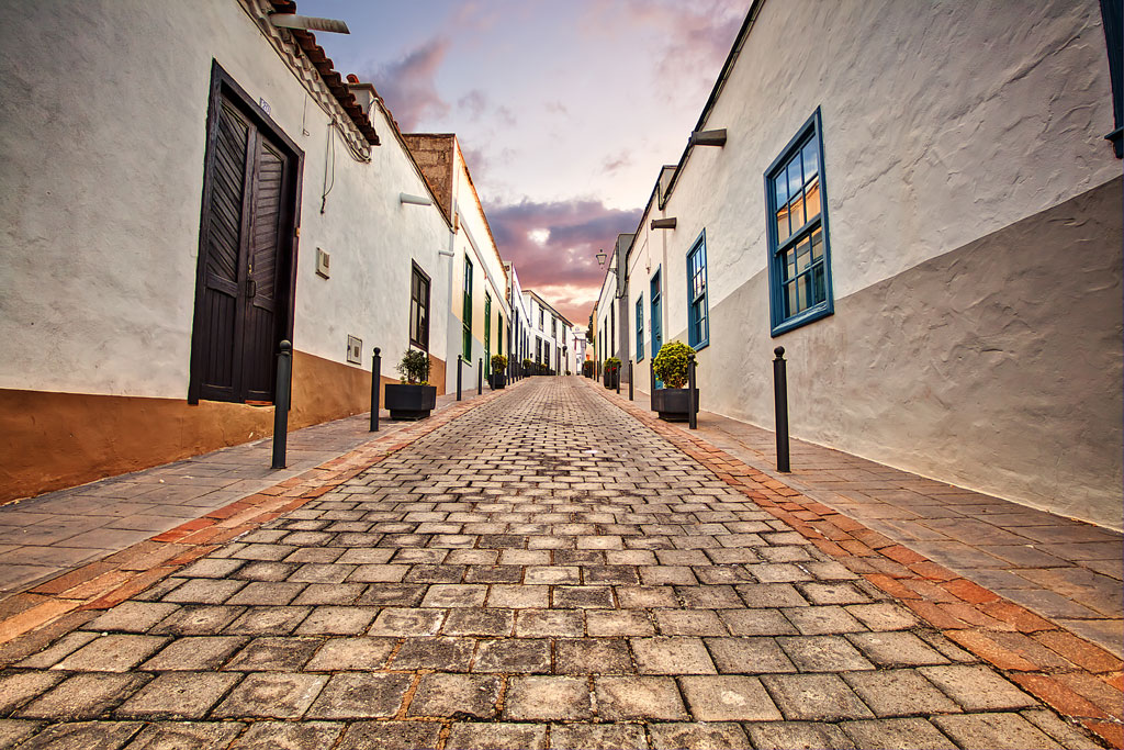 Strada acciottolata con case tradizionali a La Laguna, Tenerife, al tramonto.