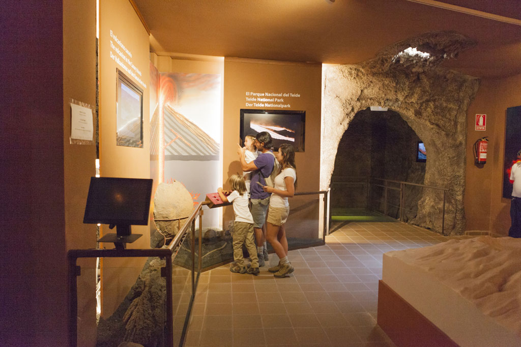 I visitatori osservano l'esposizione del Parco Nazionale del Teide all'interno di una grotta simulata.