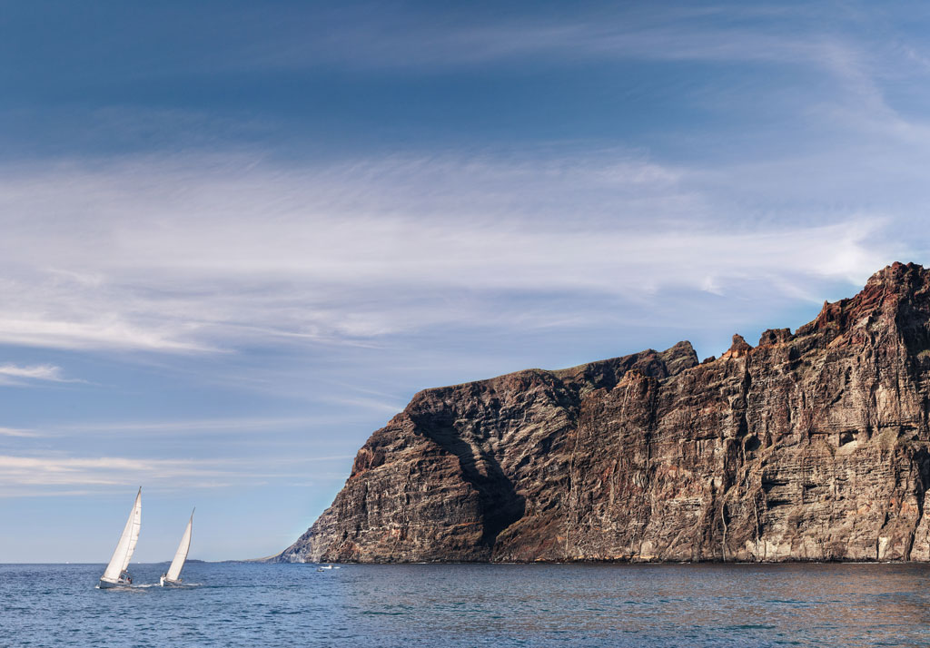 Barche a vela che navigano davanti alle scogliere di Los Gigantes, Tenerife.