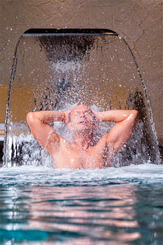 Persona sotto la cascata nella spa di Tenerife.