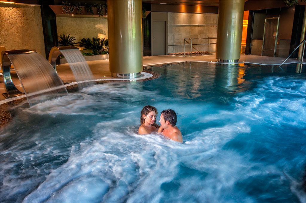 Coppia che si diverte in una piscina spa coperta a Tenerife.
