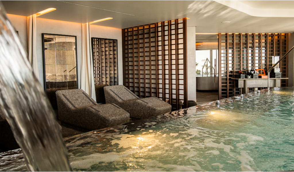 Piscina coperta con sdraioli rilassanti e pareti decorative a Tenerife.