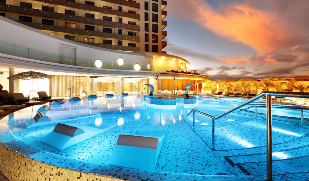 Piscina illuminata al crepuscolo in un hotel a Tenerife.